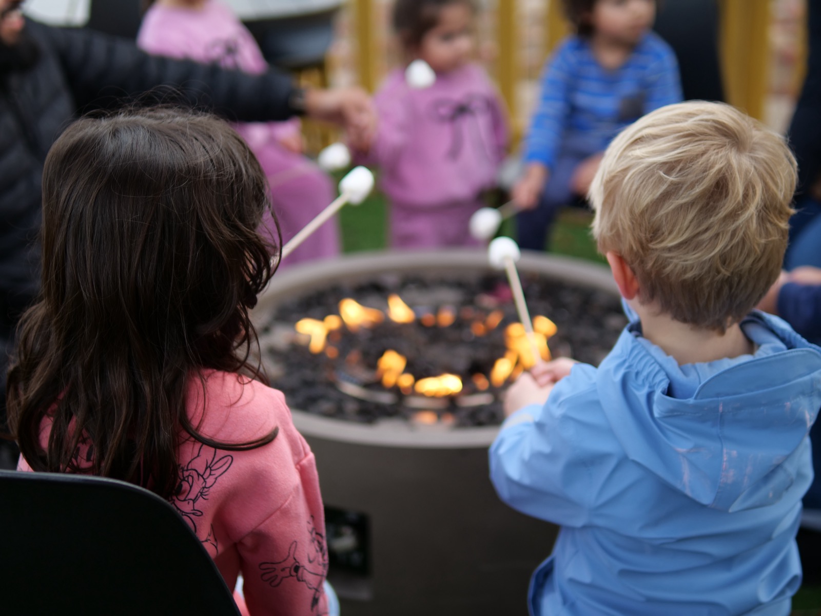 Children toasting marshmallows at the outdoor fire pit