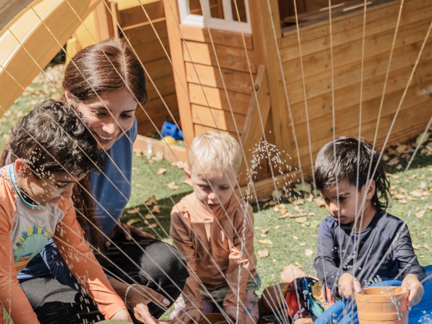 A Bamrec teacher at the water table with preschoolers